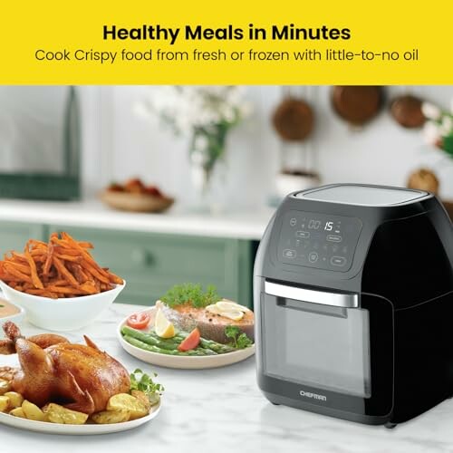 Air fryer on kitchen counter with cooked meal and fries.