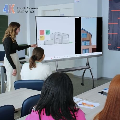 Teacher presenting architectural design on a touchscreen in a classroom.