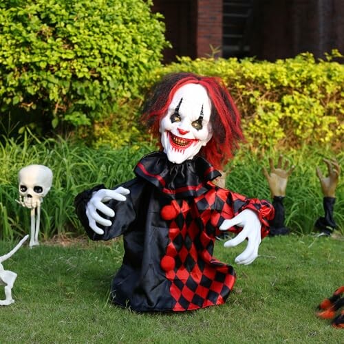 Creepy clown decoration with red and black outfit on grass