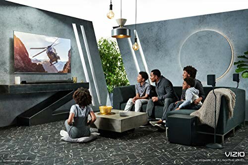 Family watching TV in a modern living room with a large screen.