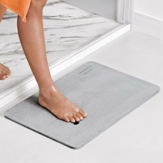 Person's foot on a gray bath mat