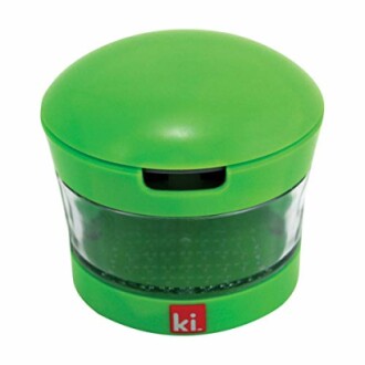 Green handheld herb grinder with transparent middle section.