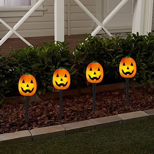 Four Halloween pumpkin pathway lights in garden