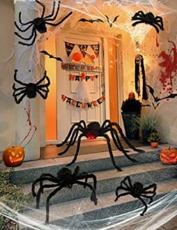 Halloween porch with giant spider decorations, pumpkins, and festive banners.