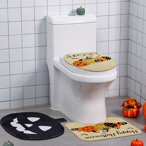 Bathroom with Halloween-themed decor including pumpkin mats and a toilet seat cover.