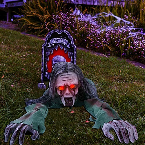 Creepy zombie decoration crawling from grave with glowing eyes