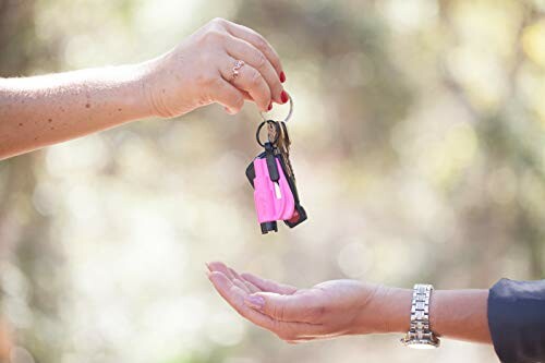 Hands exchanging car keys with a blurred background.