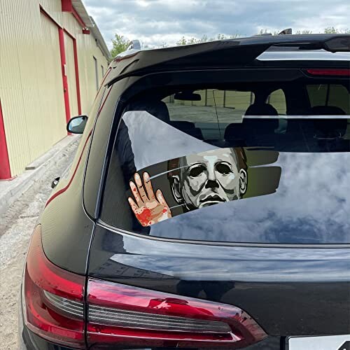 Car with horror decal on rear window.