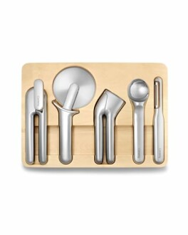 Modern kitchen utensil set with silver tools in a wooden tray.