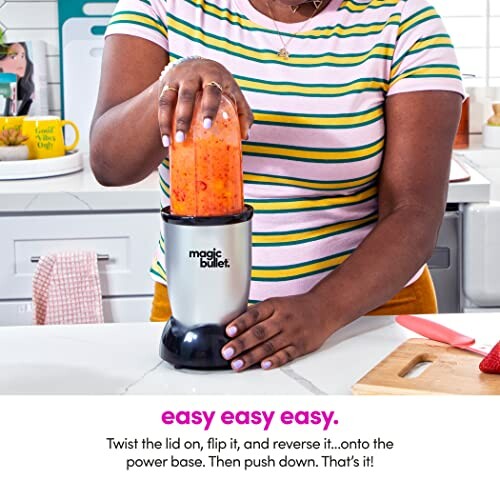 Person using a Magic Bullet blender on a kitchen counter.