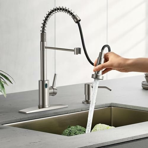 Modern kitchen faucet with pull-down sprayer over sink.