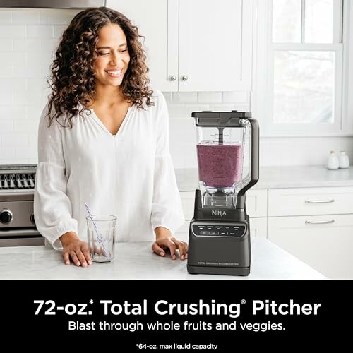 Woman with Ninja blender making a fruit smoothie in a kitchen.