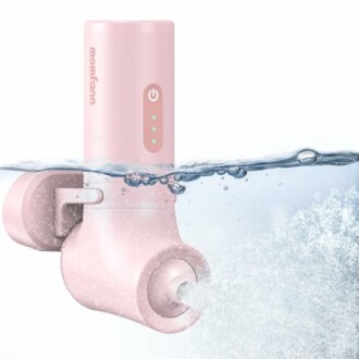 Portable electric breast pump submerged in water.