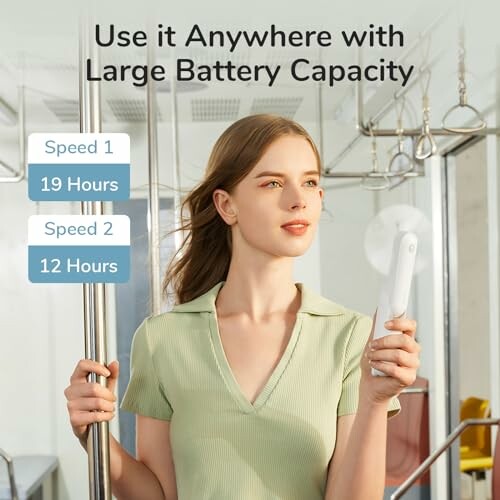Woman using portable fan with large battery capacity on public transport.
