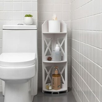 Bathroom corner shelf with toiletries and a plant.