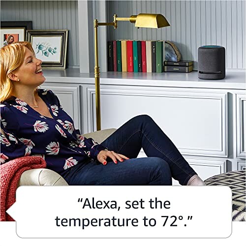 Woman sitting on a couch using a smart speaker to set the temperature.